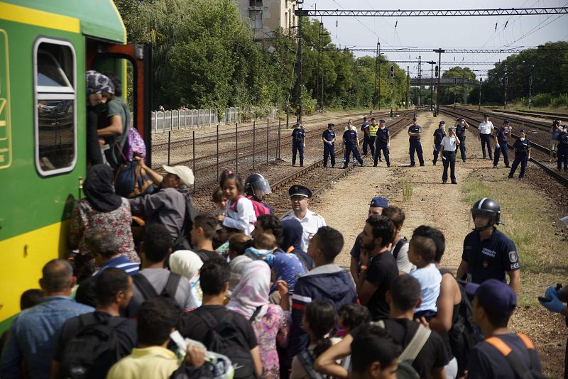 Migrantes suben a un tren en la localidad húngara de Bickse intentando aproximarse a la frontera con Austria