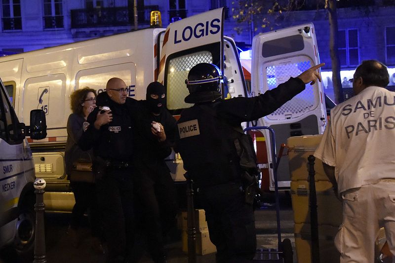 Un policía herido es ayudado por sus compañeros en las inmediaciones de la sala Bataclan