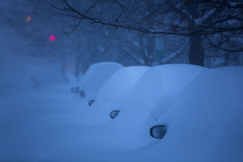 La noche cae sobre los coches desaparecidos entre la nieve