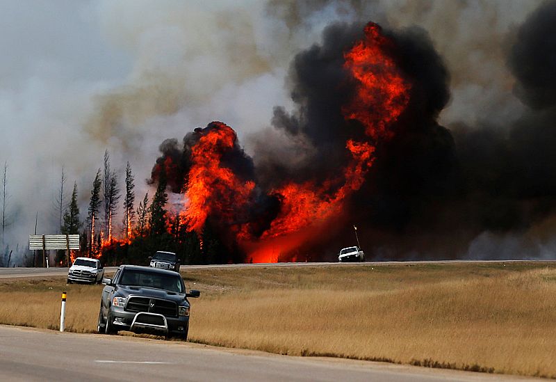 Grandes llamas tras los coches en una carretera cerca de Fort McMurray