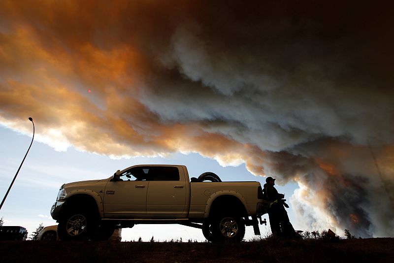 Varias personas observan las llamas cerca de Fort McMurray