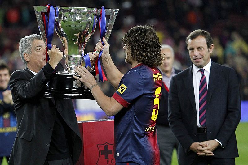 Ángel María Villar (i) entrega a Carles Puyol (c) el trofeo que les acredita como campeones de la Liga 2012-2013.