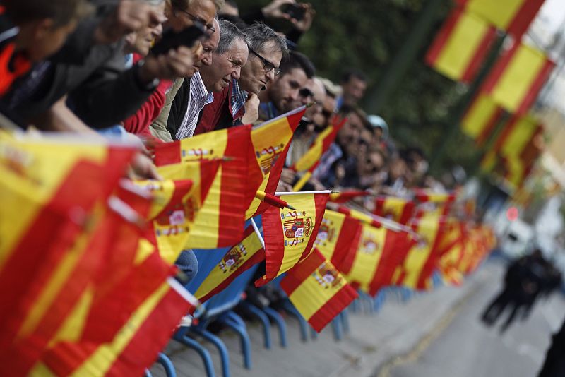 Asistentes al acto portan banderas de España en las inmediaciones de la Plaza de la Lealtad de Madrid