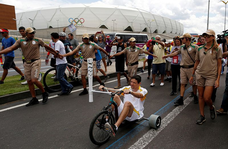 El nadador brasileño Jefferson Mascarenhas lleva la antorcha a su paso por el Arena de Amazonía de Manaos.