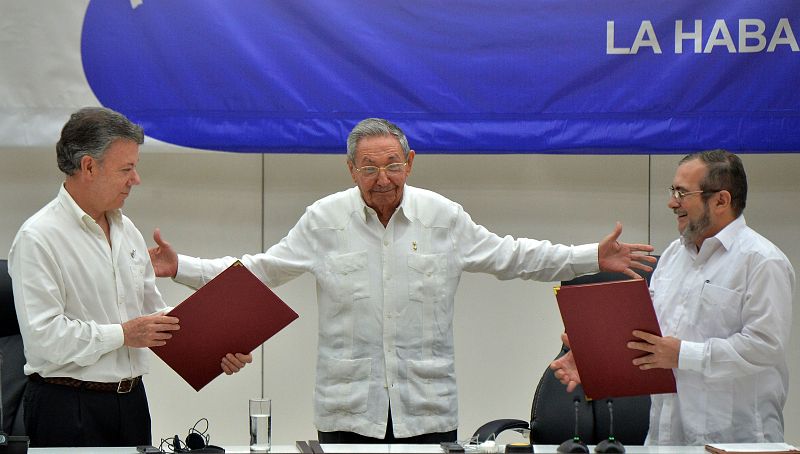 Juan Manuel Santos y "Timochenko" se intercambian los documentos que acreditan la paz entre Colombia y las FARC.