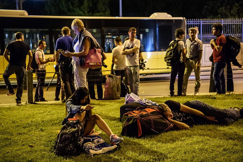 Varios pasajeros aguardan fuera del aeropuerto después del atentado
