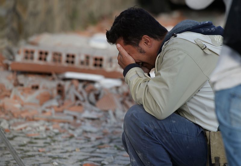 Un hombre se lamenta frente a los escombros que ha dejado un terremoto de magnitud 6 en Italia.