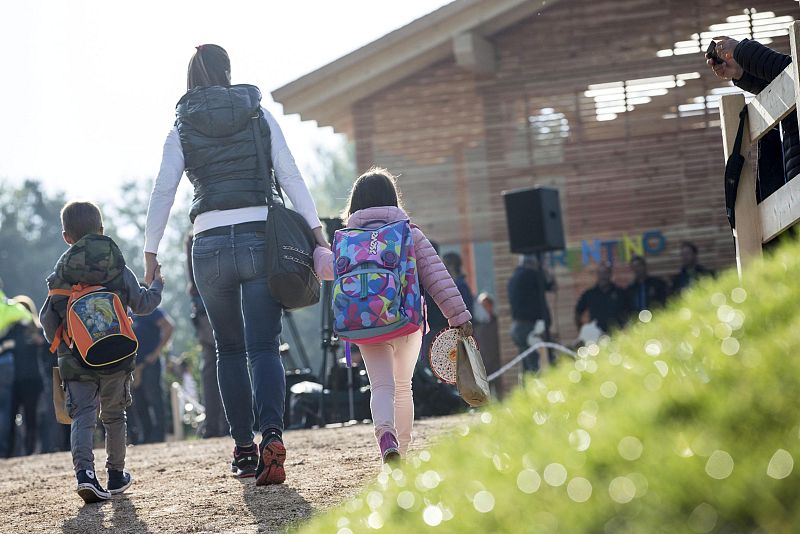 Dos niños acompañados por su madre llegan a un improvisado colegio en Amatrice, Italia.