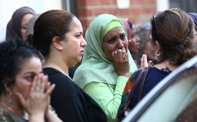 Vecinos lloran en las cercanías de la Torre Grenfell. Los testigos aseguran que han visto como algunas personas arrojaban a sus hijos por las ventanas para salvarles de las llamas.