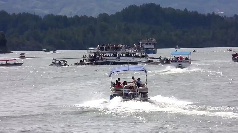 Numerosas lanchas se acercan a socorrer al barco turístico medio hundido.