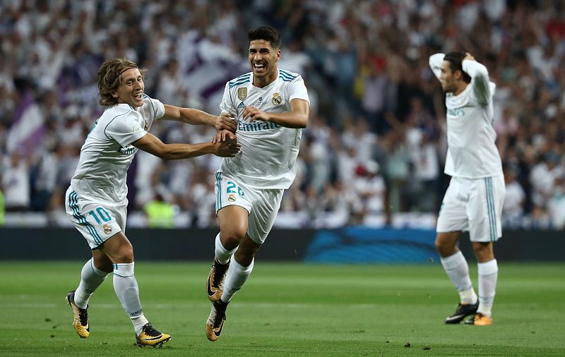 Marco Asensio celebra su gol mientras sus compañeros se llevan las manos a la cabeza.
