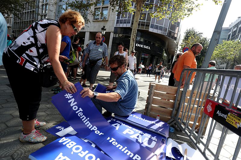 Un hombre reparte pancartas con los lemas "No tinc por" (No tengo miedo) antes de la manifestación.