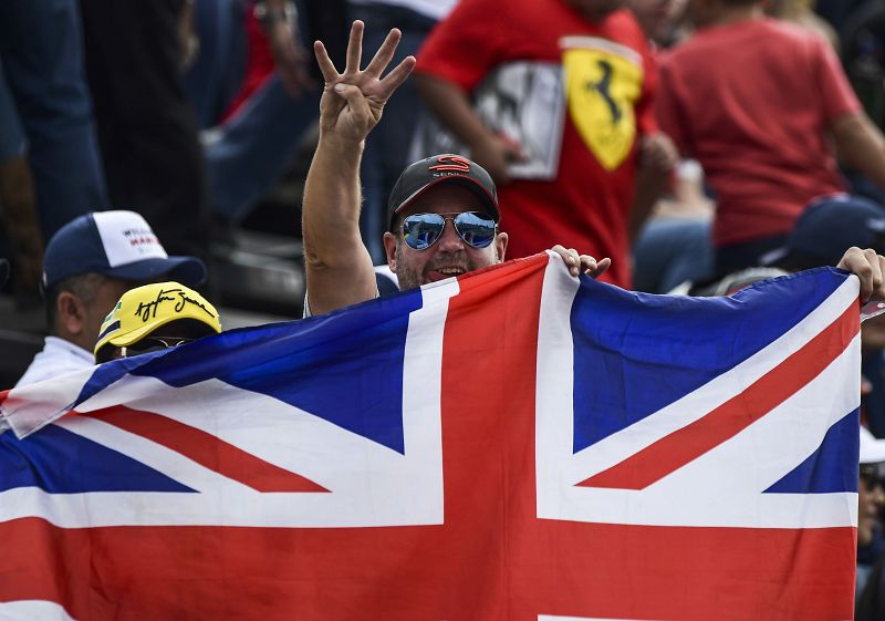 Un aficionado muestra cuatro dedos, número de campeonatos que ha logrado Hamilton.