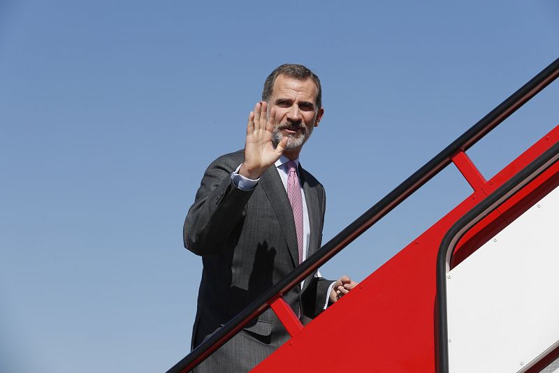 El rey sube las escaleras del avión