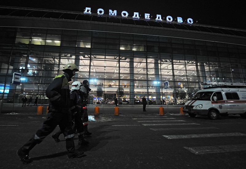 Trabajadores de los servicios de emergencia pasan delante del aeropuerto de Domodédovo