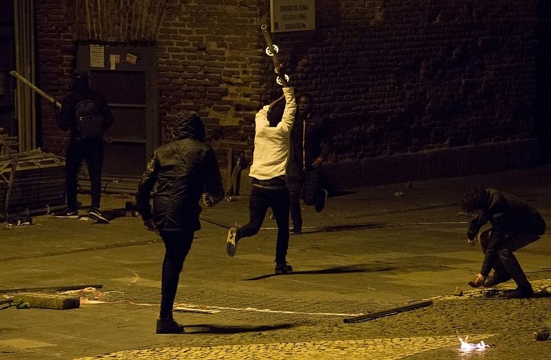 Uno de los manifestantes corre sujetando una barra de metal