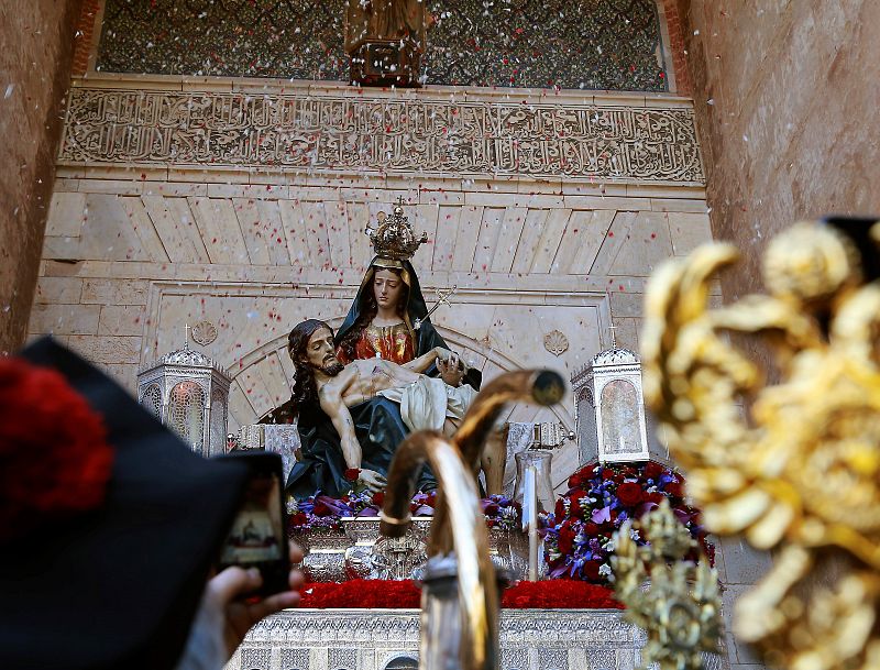Santa María de la Alhambra recibe una lluvia de pétalos tras pasar por la Puerta de la Justicia durante su procesión de Sábado Santo en Granada