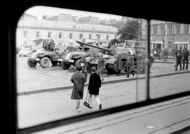 Varios ciudadanos cruzan entre los tanques y vehículos blindados soviéticos que siguen vigilantes en la Plaza de la República de Praga.