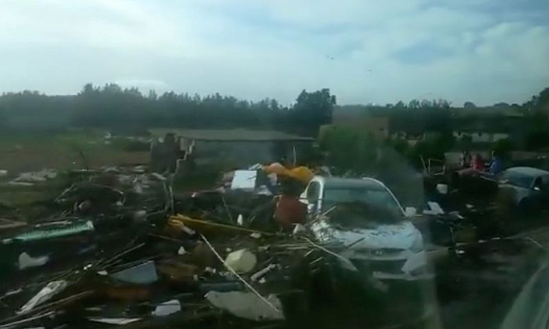 Coches y escombros se amontonan junto a la carretera