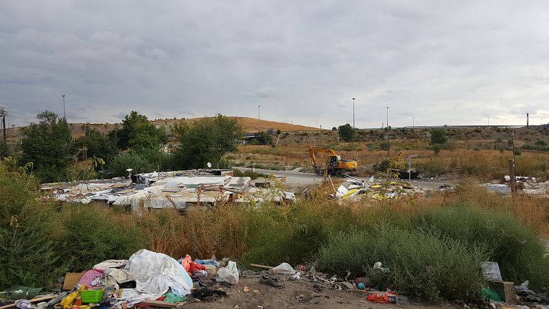 La pala esperando para entrar a derribar las chabolas que se quedan vacías