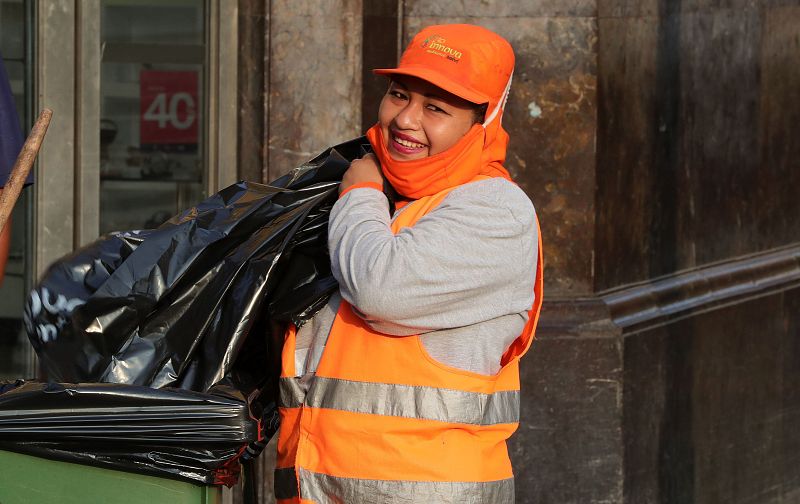 Una trabajadora de limpieza sonríe mientras desempeña sus labores este viernes, en Lima (Perú).