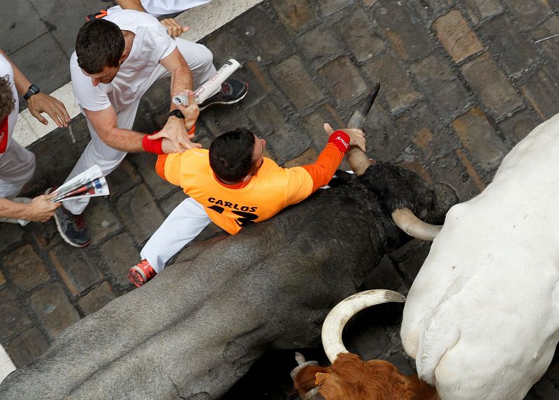 Otro mozo agarra el pitón del astado en Estafeta