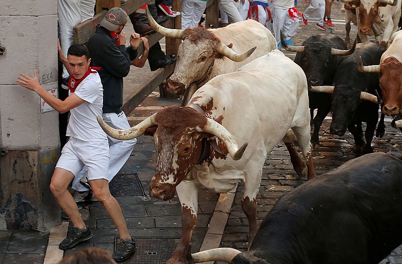 Un participante en el encierro dobla una esquina
