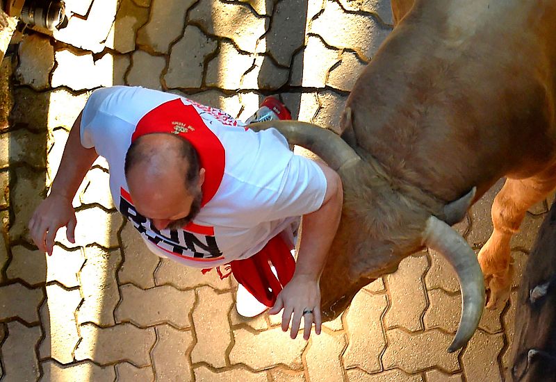 Un toro se acerca mucho a un corredor