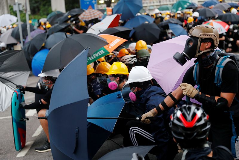 Los manifestantes se protegen con paraguas