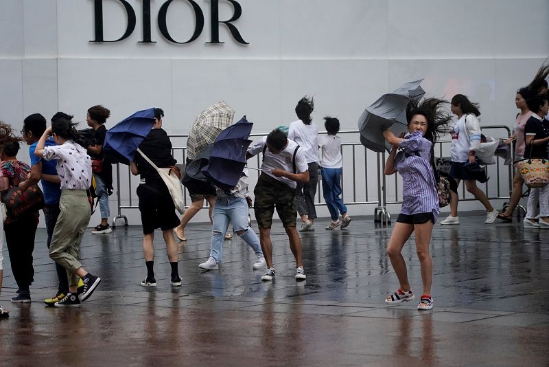 Numerosas personas caminan y realizan compras en Shangahi durante el tifón Lekima.