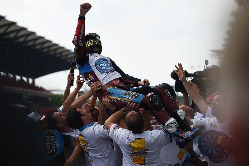 Alex Márquez e3s manteado por sus compañeros de equipo.