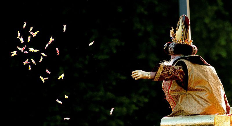 El rey Melchor reparte caramelos desde su carroza