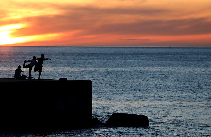 Un grupo de personas hacen ejercicio en la playa de la Barceloneta durante las horas en que se permite el ejercicio individual al aire libre.
