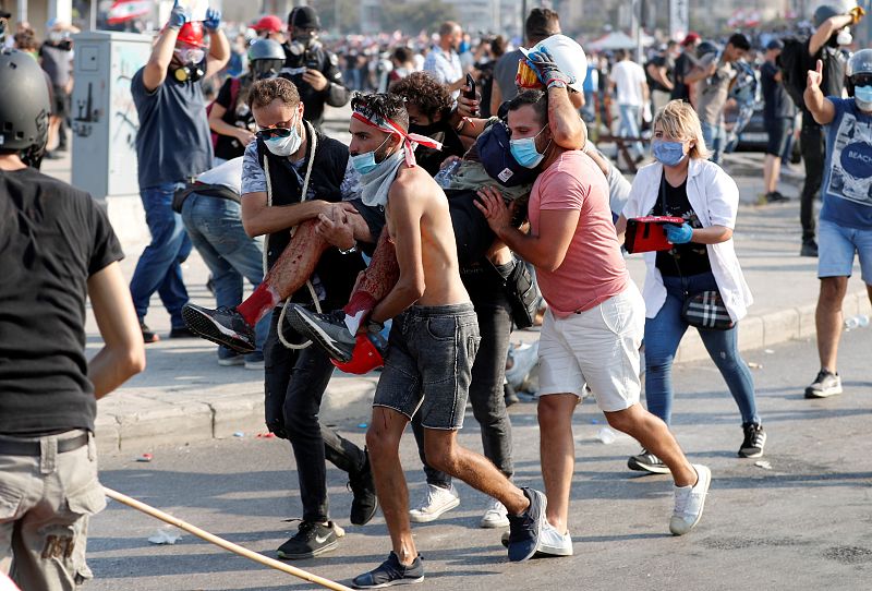 Varios manifestantes cargan con un herido en las protestas