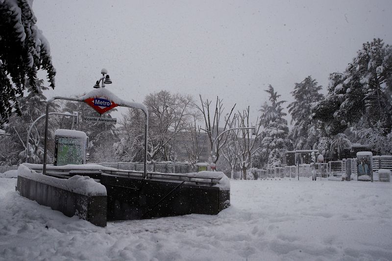 Entrada a la estación de metro Vicente Aleixandre cubierta de nieve en Madrid.