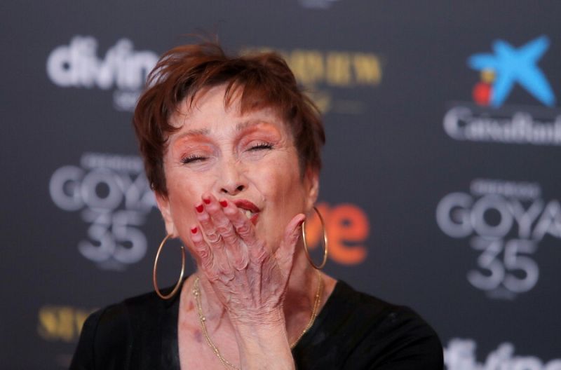 La actriz en la alfombra roja, lanza un beso muy sonriente.