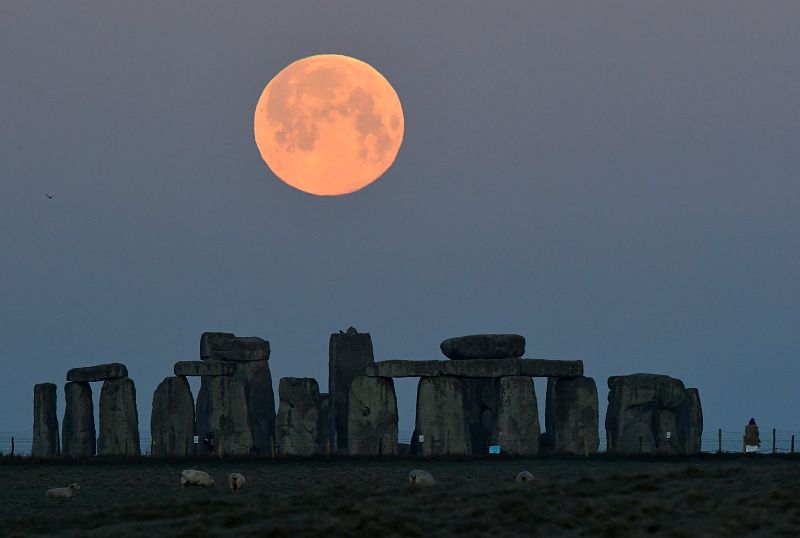 La superluna rosa se pone detrás del conjunto de piedra de Stonehenge cerca de Amesbury, Reino Unido.