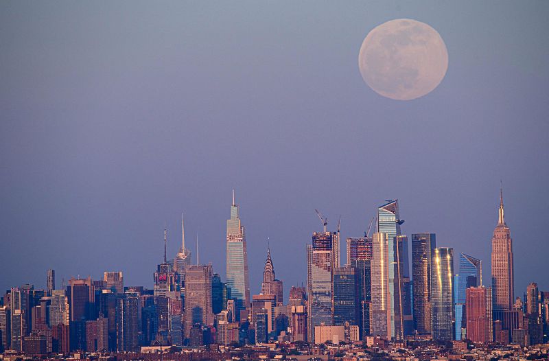 La luna llena de abril se eleva en el horizonte de Manhattan.