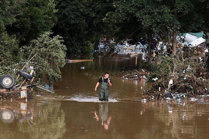 Un hombre camina por el agua en una zona afectada por las inundaciones tras las fuertes lluvias