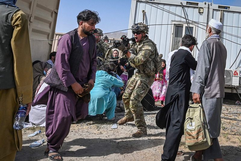 Un soldado estadounidense apunta a un afgano en el aeropuerto, donde se producen escenas de desesperación y caos. Foto: Wakil KOHSAR / AFP