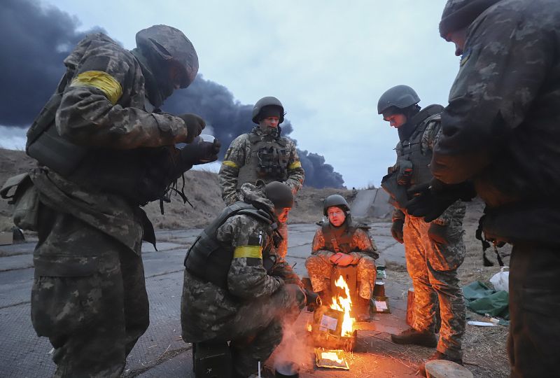 Soldados ucranianos se calientan en una hoguera en las inmediaciones de Kiev