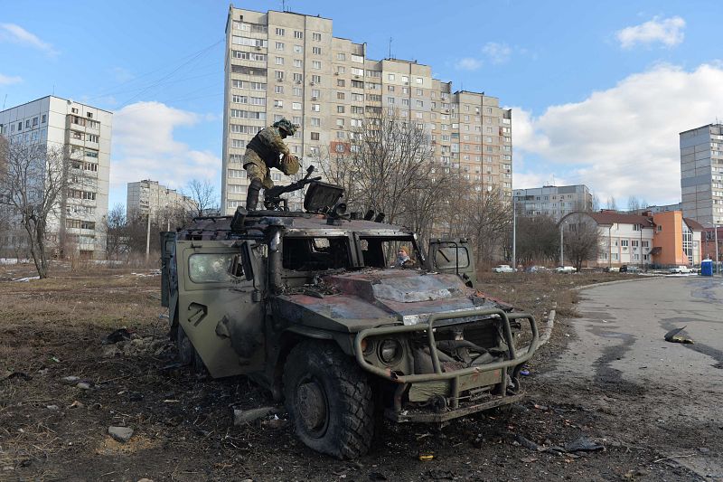 Un luchador de Defensa Territorial de Ucrania examina un vehículo blindado de transporte de personal (APC) ruso destruido después de la batalla en Kharkiv