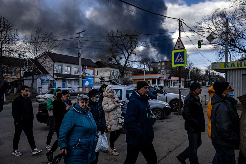 La gente hace fila frente a un supermercado mientras el humo se eleva sobre la ciudad de Vasylkiv, en las afueras de Kiev