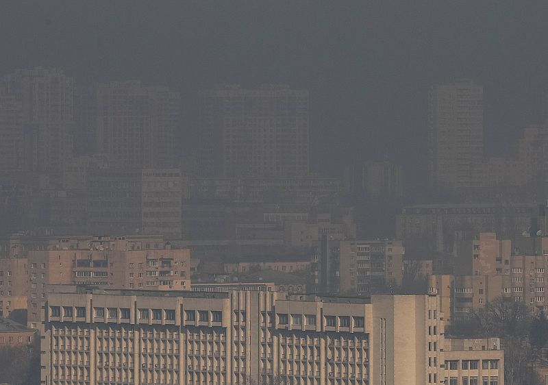 Residential buildings in Kyiv are seen through smoke from fires after shelling nearby