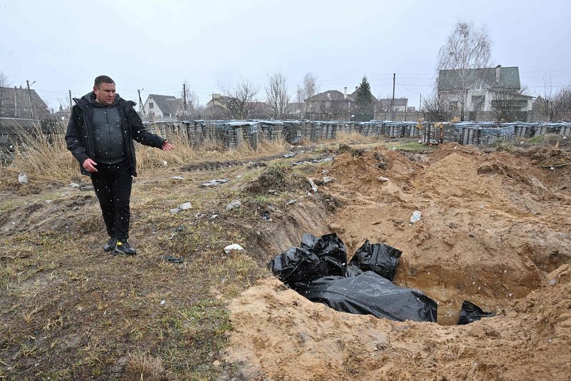 Un hombre señala una fosa común en la ciudad de Bucha, al noroeste de la capital ucraniana, Kiev.
