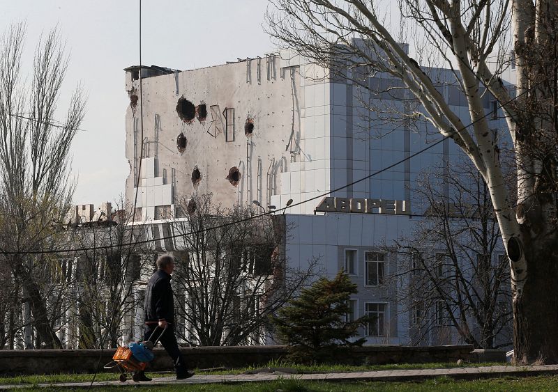 Un residente local pasa por delante del Palacio de la Cultura dañado durante el conflicto en la ciudad portuaria del sur de Mariupol, Ucrania. 