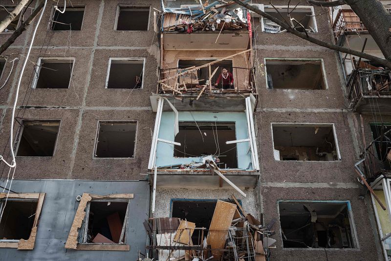 Una mujer en un balcón limpia su habitación en un apartamento dañado por la explosión de un misil en Kramatorsk