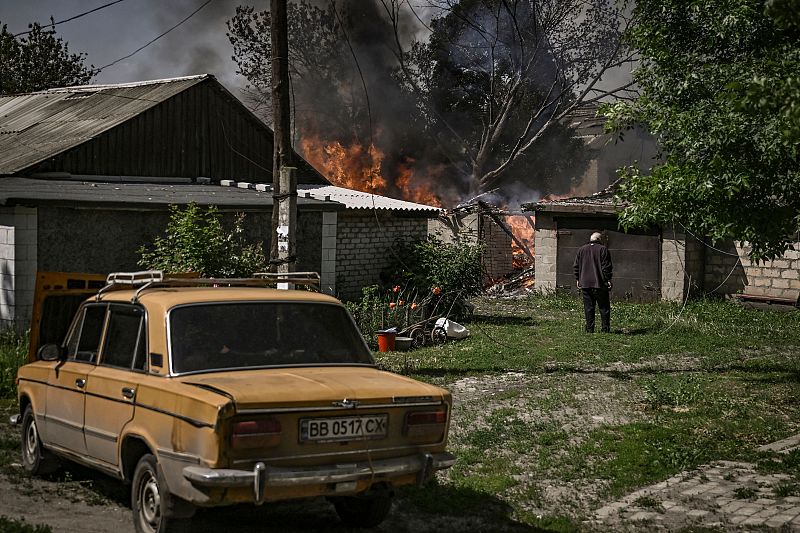 Un anciano frente a un garaje de una casa en llamas tras un bombardeo en la ciudad de Lysytsansk en la región oriental ucraniana de Donbás.
