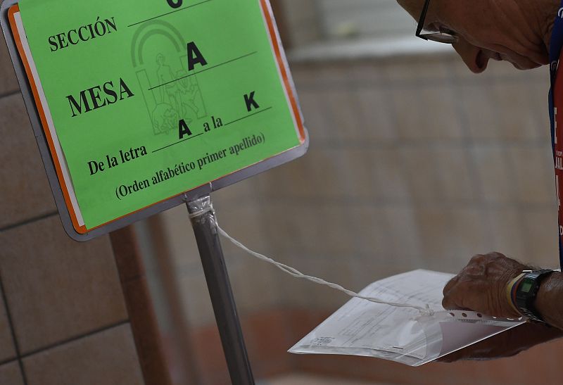 Una persona busca su nombre en uno de los listados del colegio Ntra. Sra. del Milagro de Almería