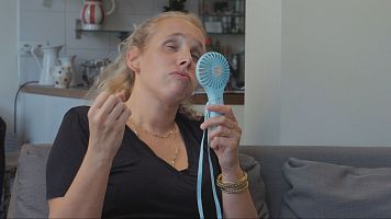 mujer con ventilador de mano